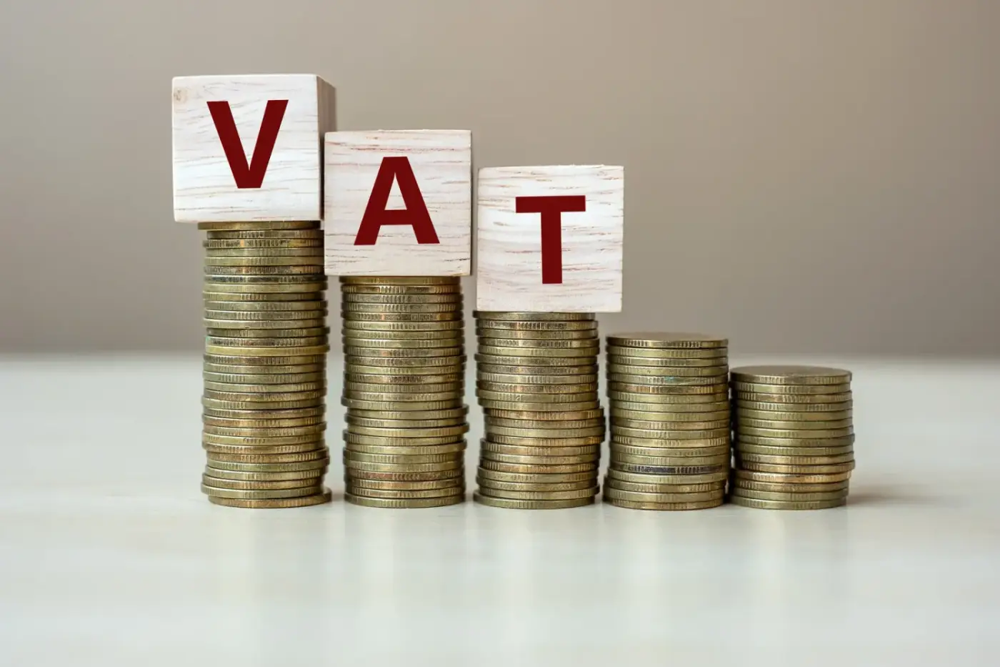 vat-wooden-cube-with-golden-coin-on-growing-money vat-wooden-cube-with-golden-coin-on-growing-money